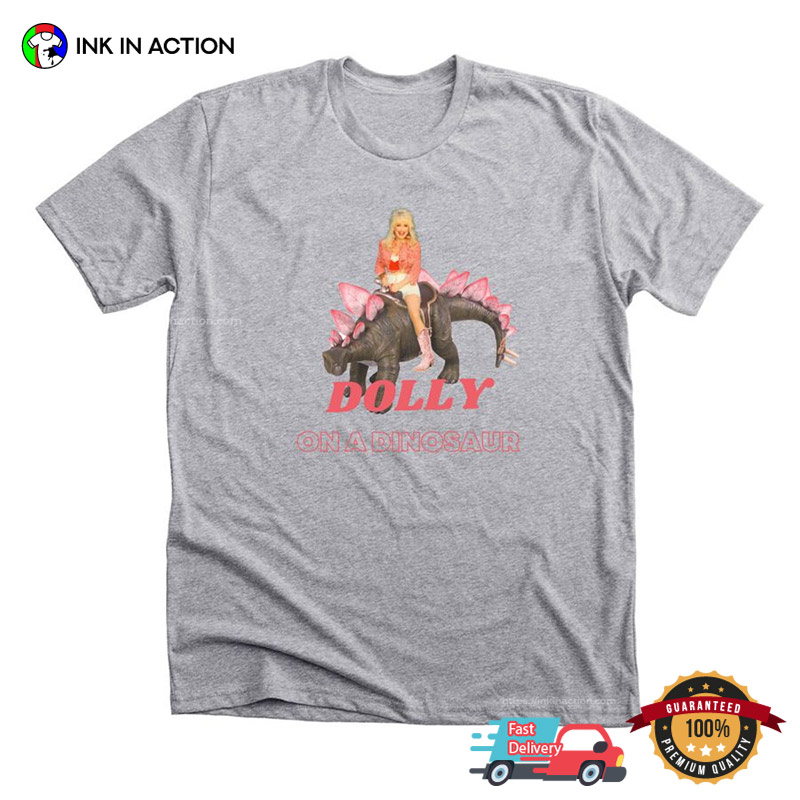 Dolly On A Dinosaur, Dolly Parton Cartoon Graphic T-shirt Dolly On A Dinosaur, Dolly Parton Cartoon Graphic T-shirt
